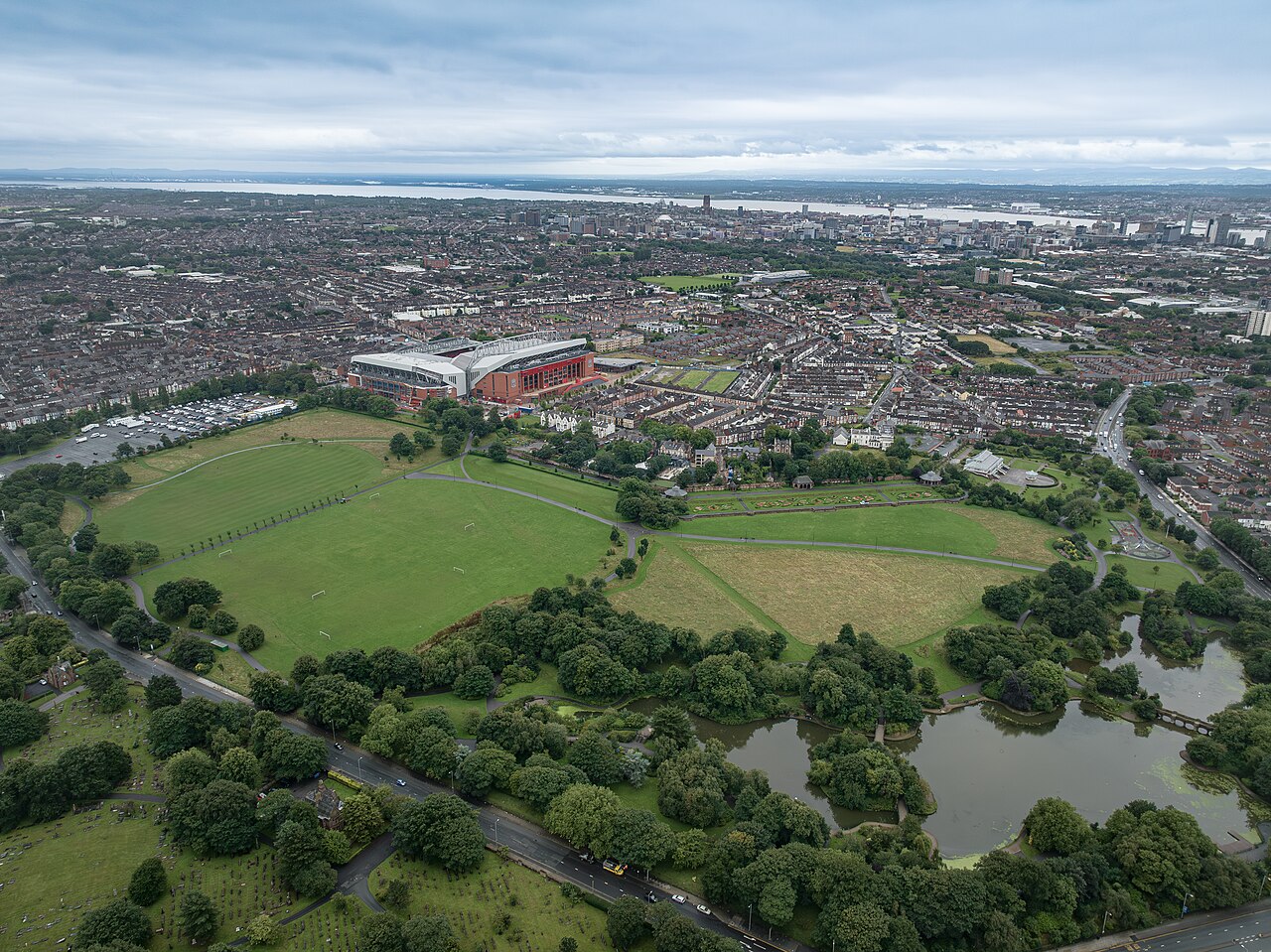 Aerial view of Anfield seen across Stanley Park, with Liverpool city centre and the River Mersey in the distance